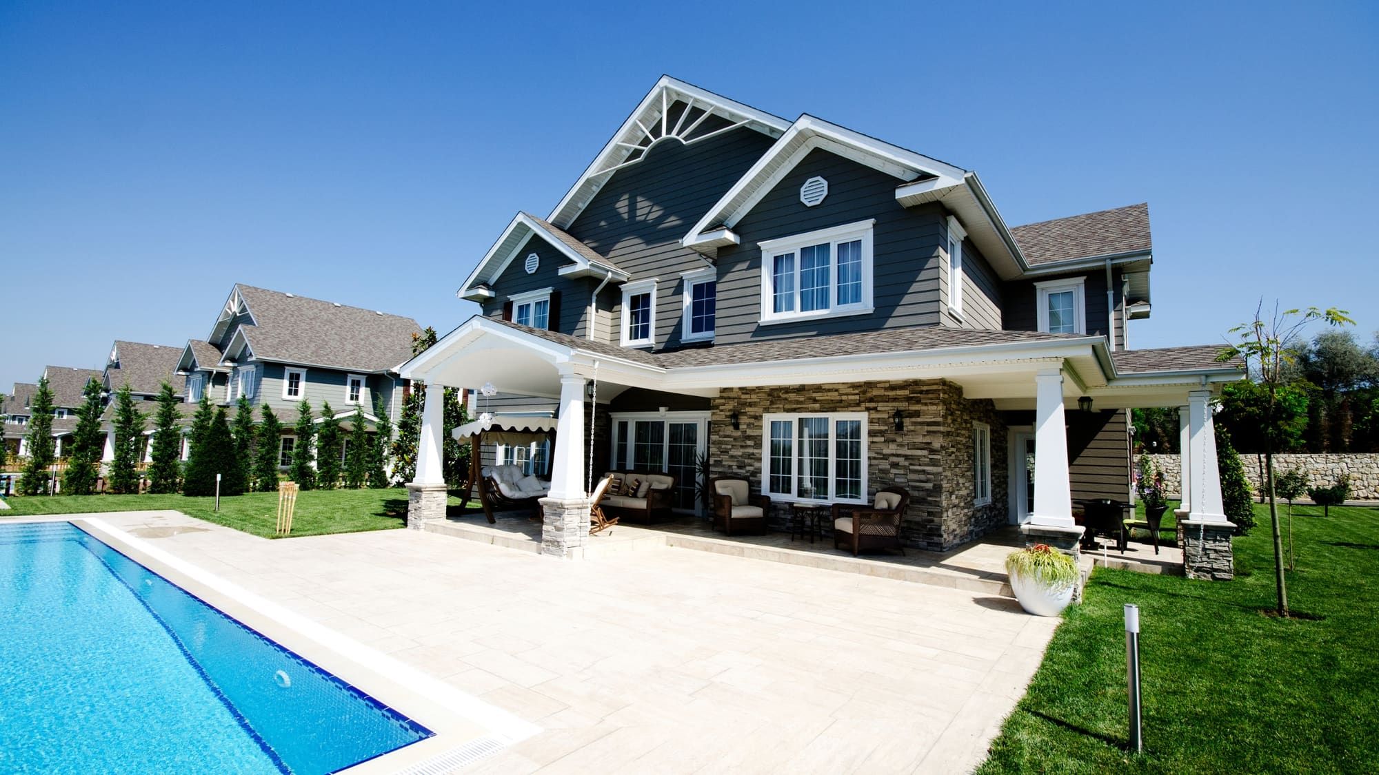 Daytime photo of a craftsman home with pool captured for a real estate listing