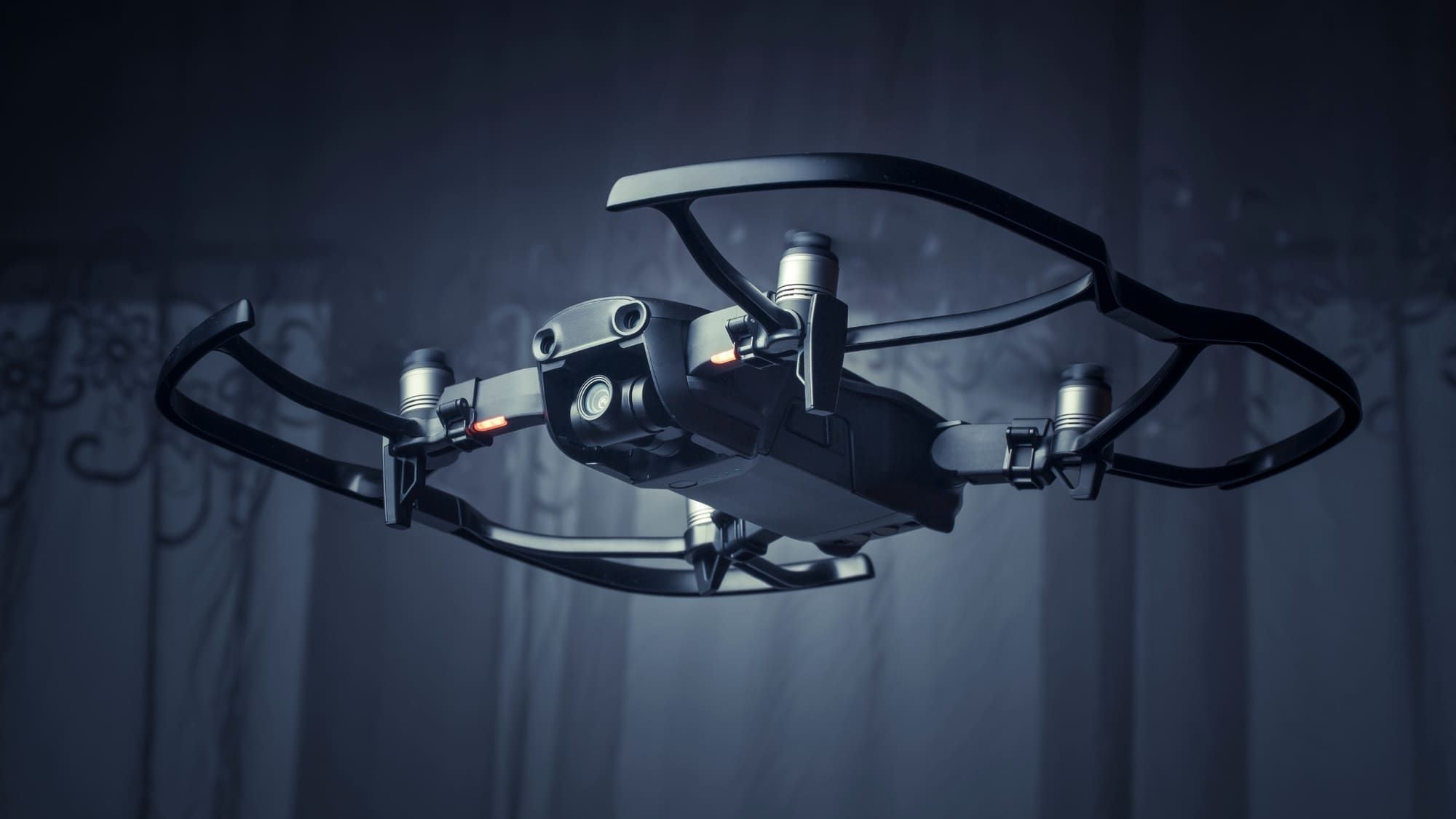 Camera drone hovering in low light with status lights illuminated