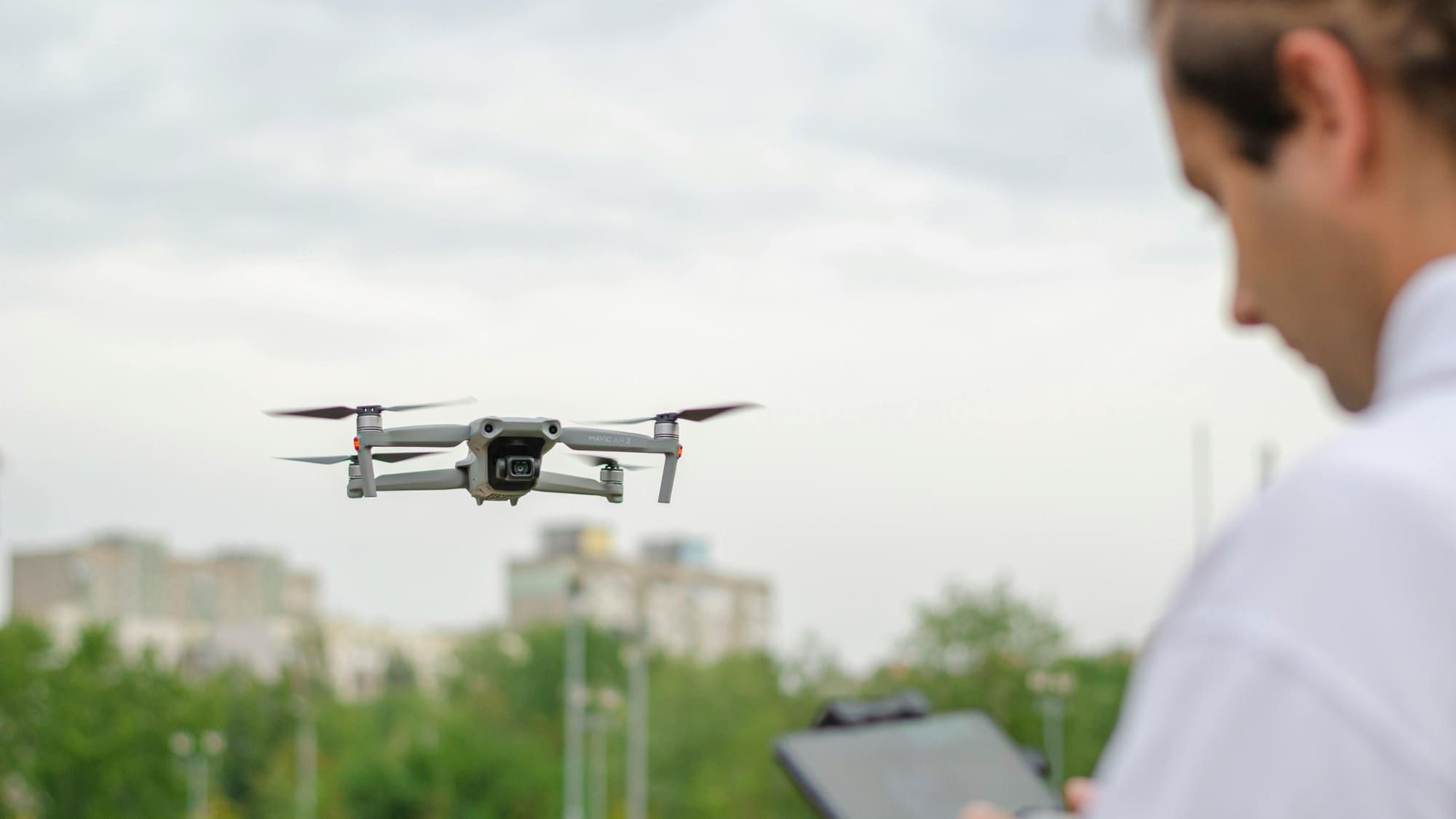 FAA-certified drone pilot flying a DJI drone with a remote controller