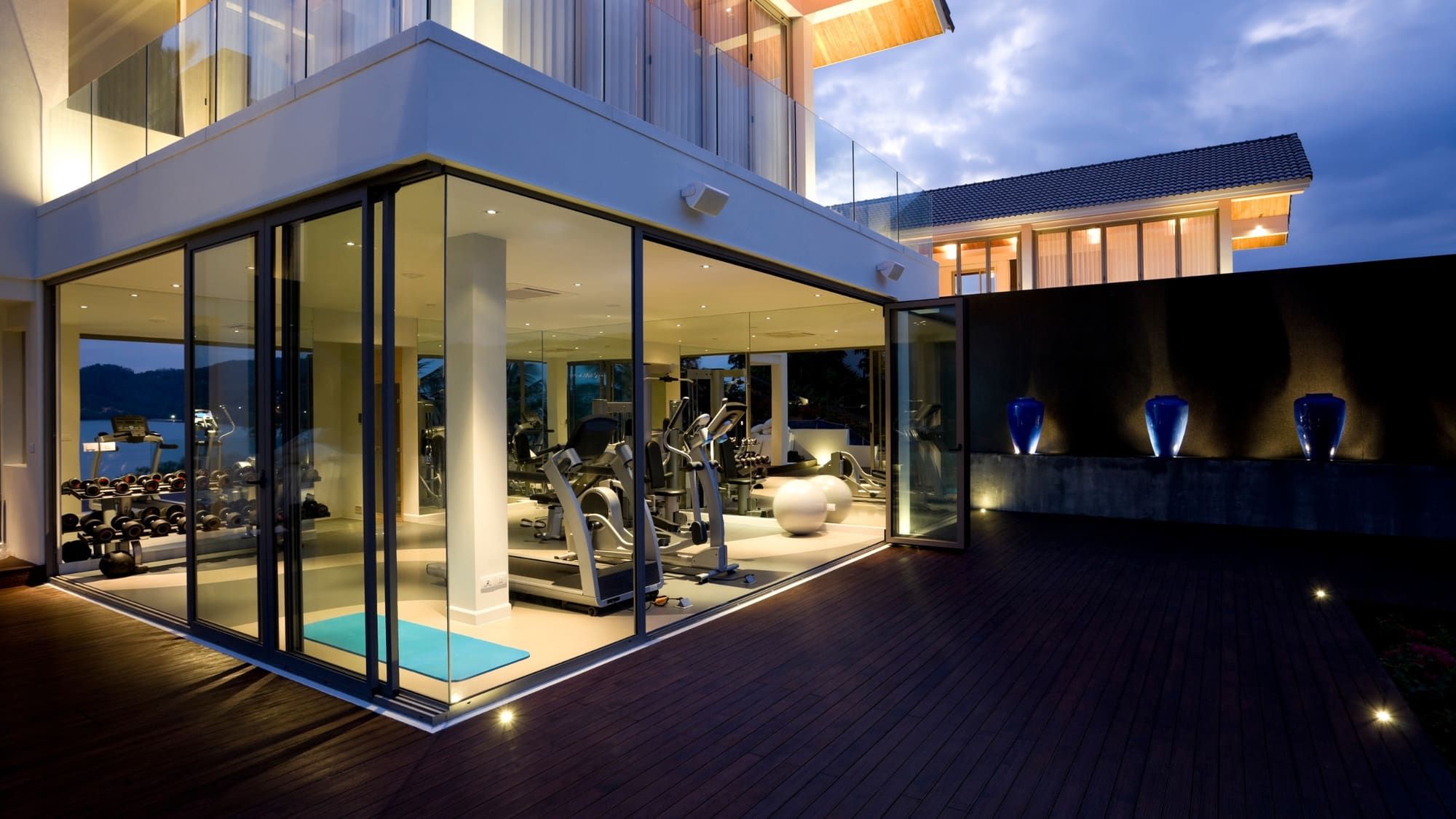 Twilight photo of modern glass architecture with warm interior lighting