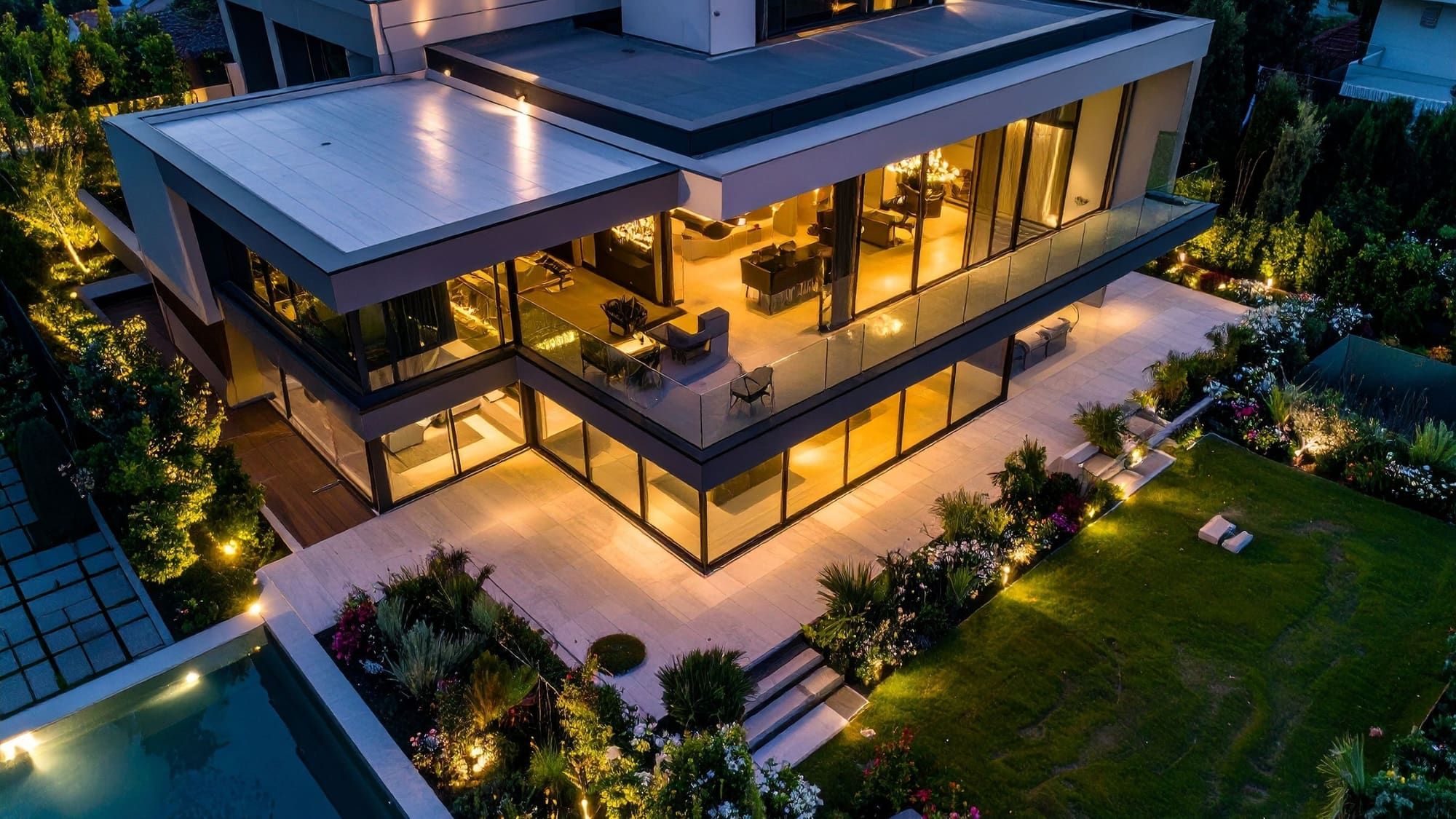 Twilight aerial photo of a modern luxury home with glowing interior lights